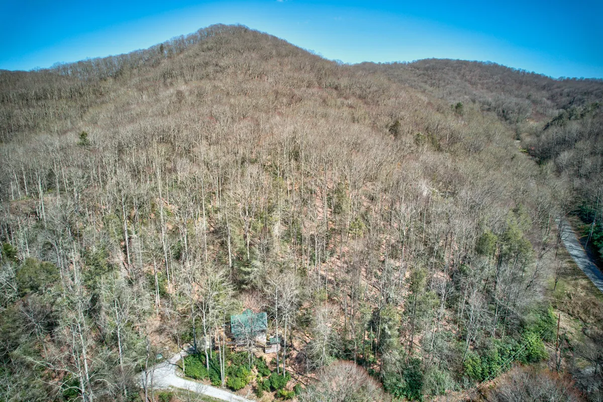 A gently curving trail leads through wooded hills to a gazebo, surrounded by greenery. The scene captures the essence of nearby hiking opportunities, peaceful walks, and birdwatching. The elevated vantage point hints at sweeping views and open skies, reinforcing a sense of tranquility and discovery.